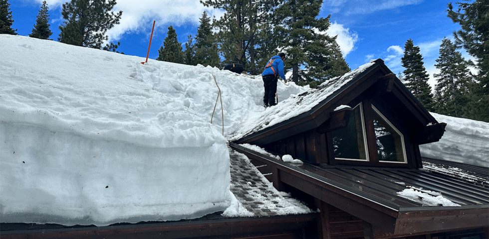 Man removing ice from roof.