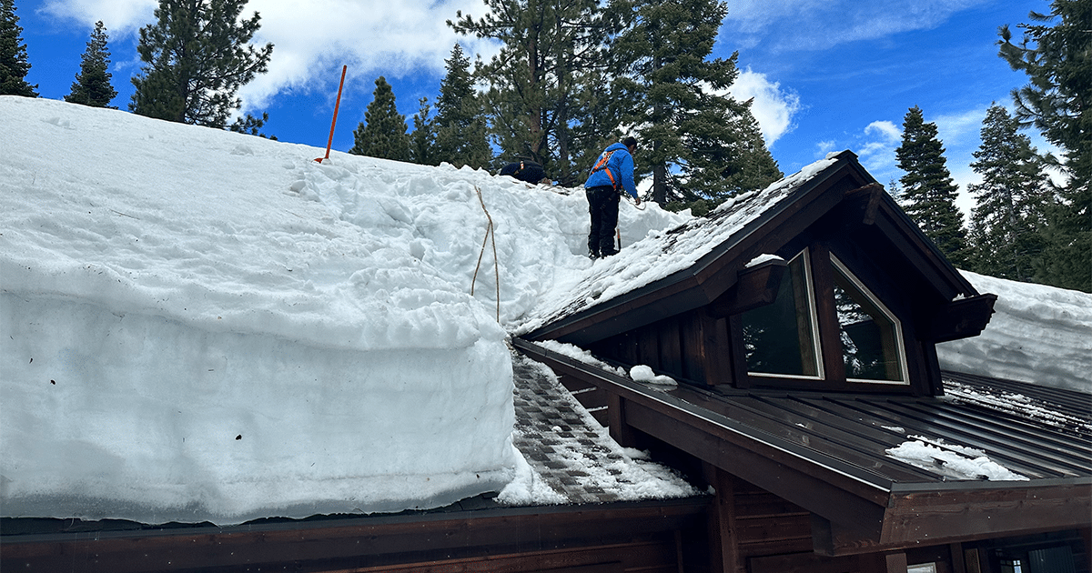 Man removing ice from roof.