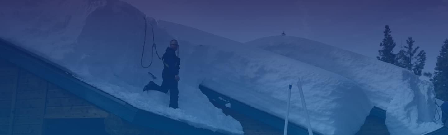 Snowy Nevada roof with Mills Roofing employee removing snow