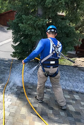 Mills Roofing employee applies Roof Maxx